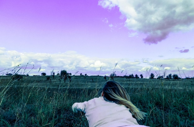 Foto mujer en el campo agrícola contra el cielo