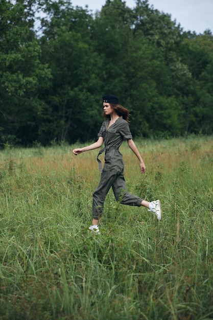 Mujer en el campo corre sobre la hierba en un mono verde