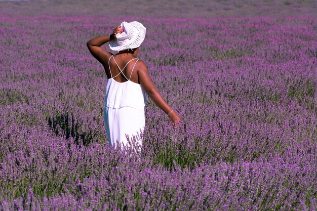 Mujer en un campo de flores de lavanda con vestido blanco, España