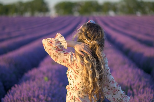 Mujer en campo de lavanda al atardecer con vestido de verano