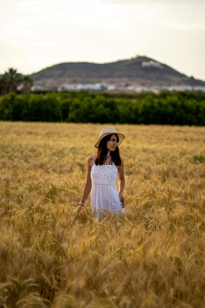 Foto una mujer en un campo de trigo mira a la cámara.