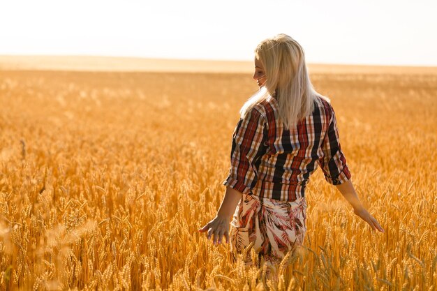 mujer, en, un, campo de trigo, en, el, plano de fondo, de, el, sol poniente