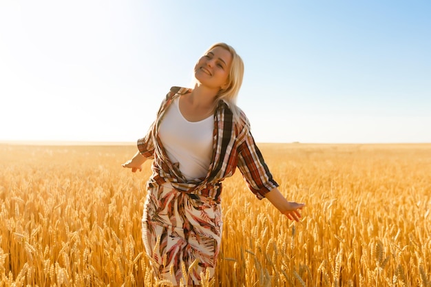 mujer, en, un, campo de trigo, en, el, plano de fondo, de, el, sol poniente