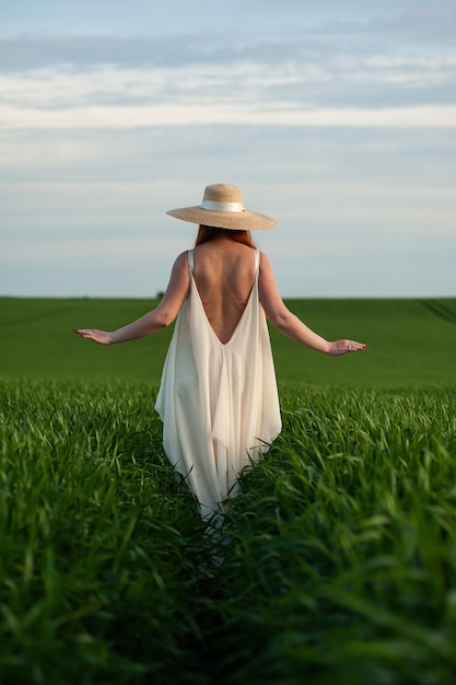 Mujer en el campo verde en vestido blanco