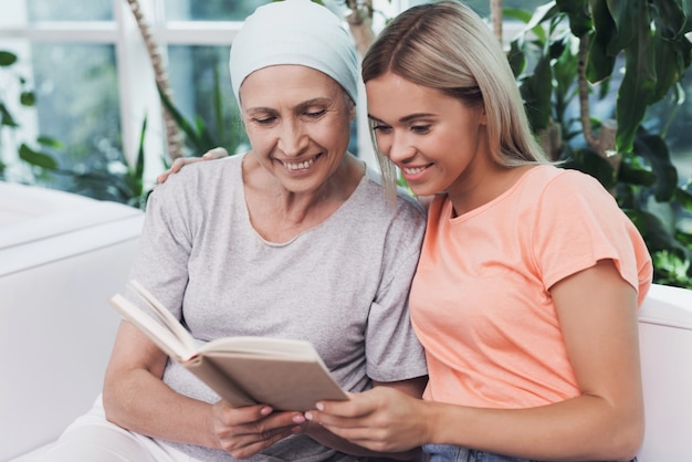 Una mujer con cáncer está sentada junto a su hija.