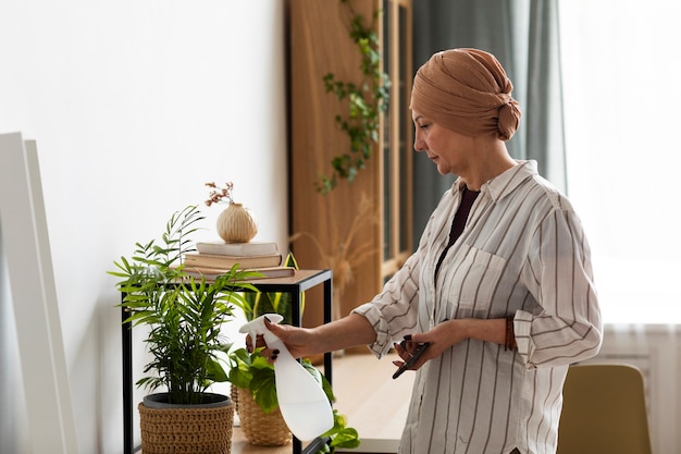 Foto mujer con cáncer de piel cuidando sus plantas