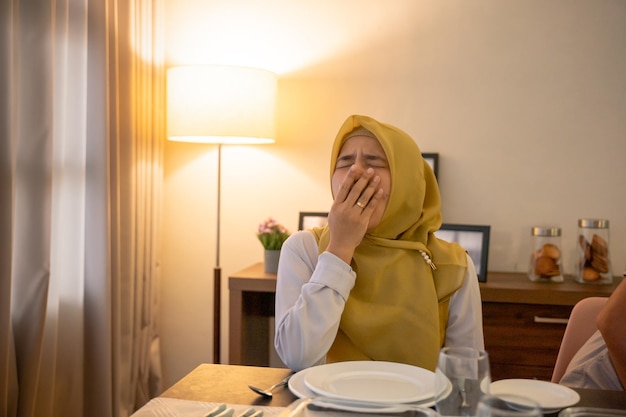 Mujer cansada desayunando o sahur por la mañana