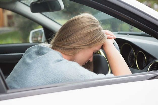 Mujer cansada dormida en el volante