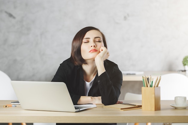 Mujer cansada en el escritorio de la oficina