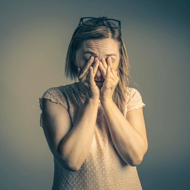 Mujer cansada se frota los ojos