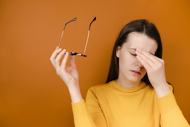 Mujer cansada quitándose gafas