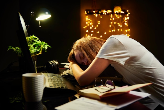 Mujer cansada trabaja hasta tarde en casa lugar de trabajo