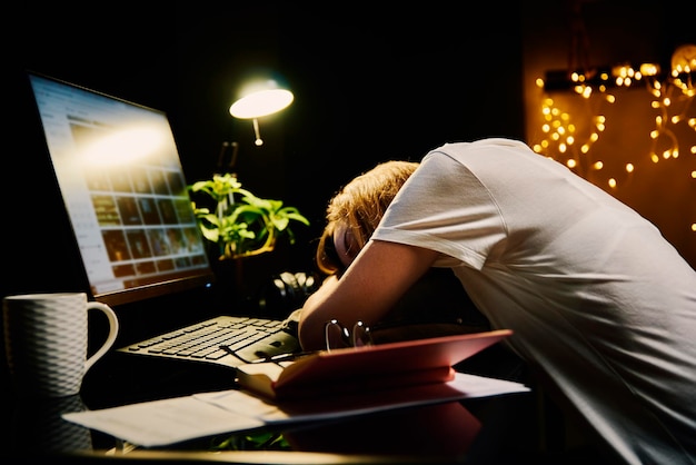 Mujer cansada trabaja hasta tarde en casa lugar de trabajo