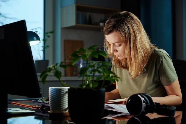 Mujer cansada trabaja hasta tarde en el lugar de trabajo en casa por la noche