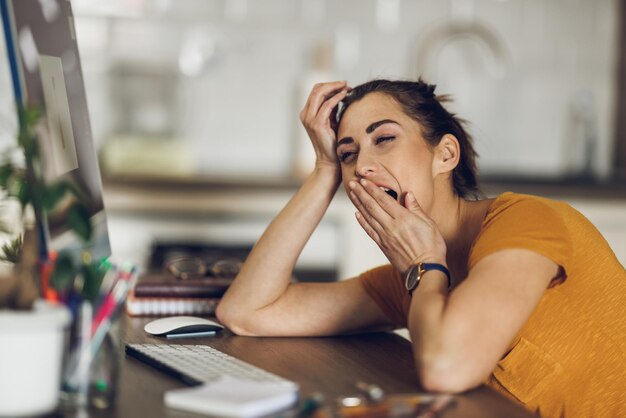 Mujer cansada trabajando en casa