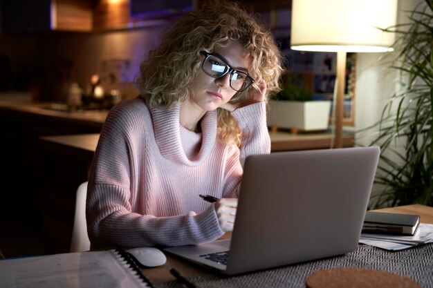 Mujer cansada trabajando hasta tarde en casa