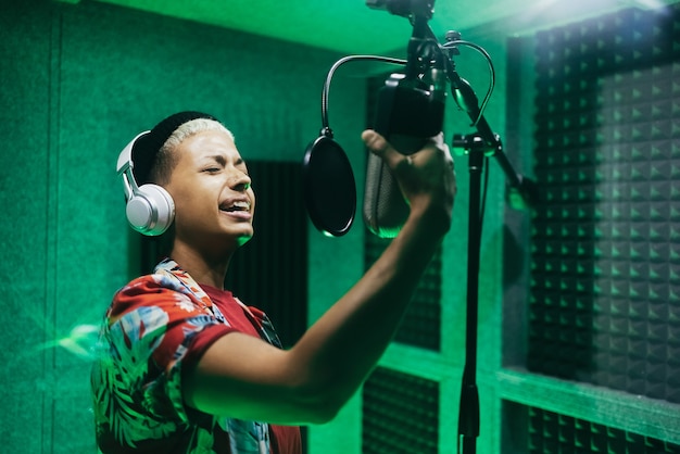 Mujer cantante grabando nuevo álbum de música dentro del estudio boutique - Centrarse en la cara