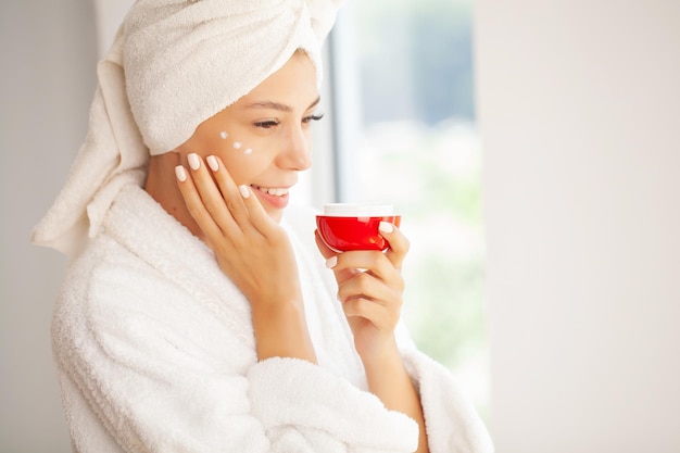 Mujer con cara de belleza tocando un retrato de piel facial saludable