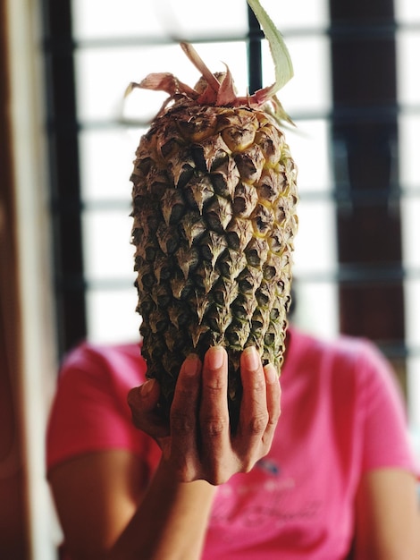 Foto mujer con la cara cubierta de piña