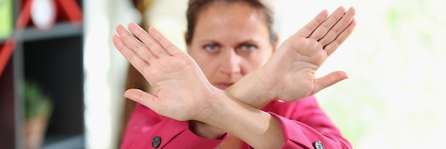 Mujer con cara seria muestra los brazos cruzados como símbolo de no parar negado y rechazar infeliz