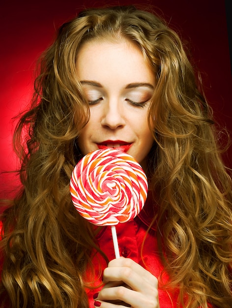 Foto mujer con caramelo de corazón