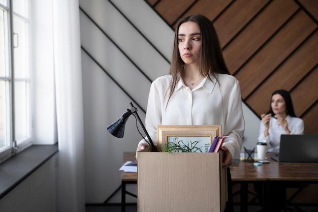 Mujer cargando caja de cartón plano medio