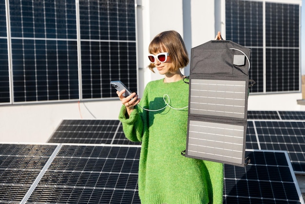 Mujer cargando teléfono desde un panel solar portátil