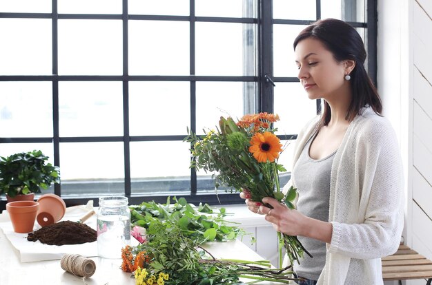 Foto mujer en casa haciendo un ramo de flores