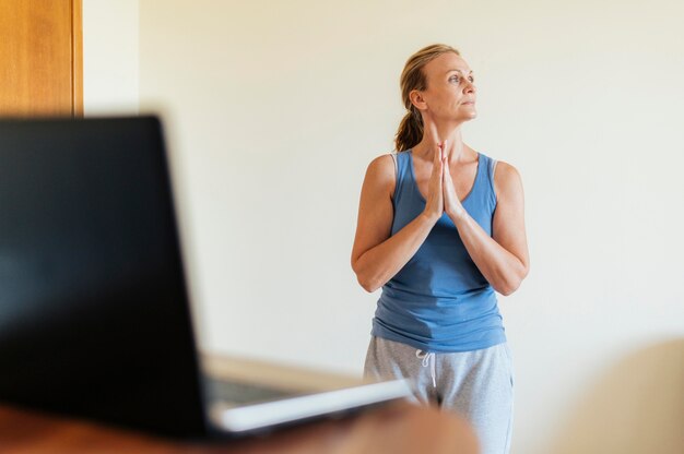 Foto mujer en casa haciendo yoga durante la cuarentena