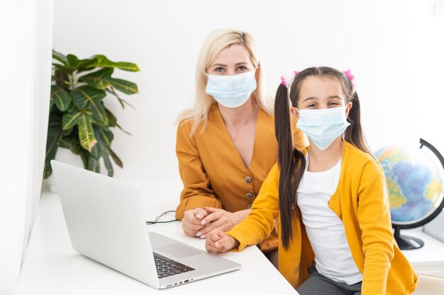 Foto mujer en casa con niño ayudando con la enseñanza en línea - coronavirus.