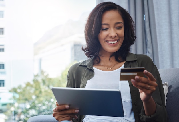Mujer en casa y sonríe en la tableta con tarjeta de crédito para la verificación de detalles y finanzas de la casa Mujer persona sala de estar y feliz con la compra en línea para el presupuesto de banca por Internet y la inversión