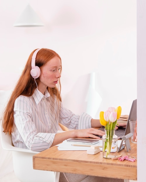 Mujer en casa trabajando en equipo portátil