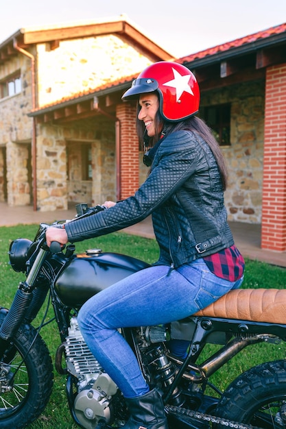 Mujer con casco montando moto custom