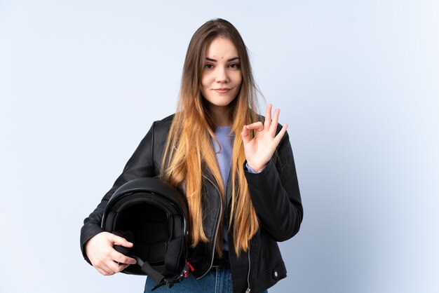 Mujer con casco de moto mostrando un signo bien con los dedos