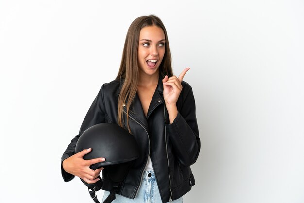 Mujer con un casco de motocicleta sobre fondo blanco aislado con la intención de darse cuenta de la solución mientras levanta un dedo hacia arriba