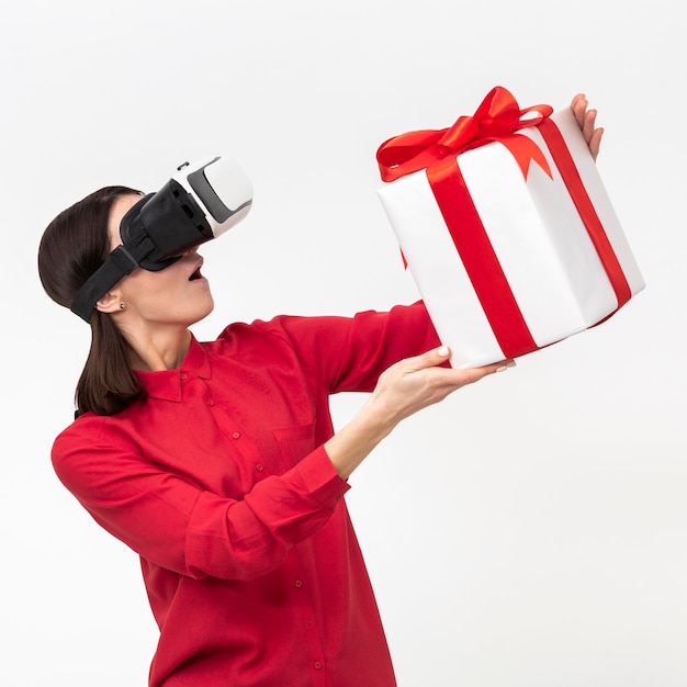 Foto mujer con casco de realidad virtual con caja de regalo