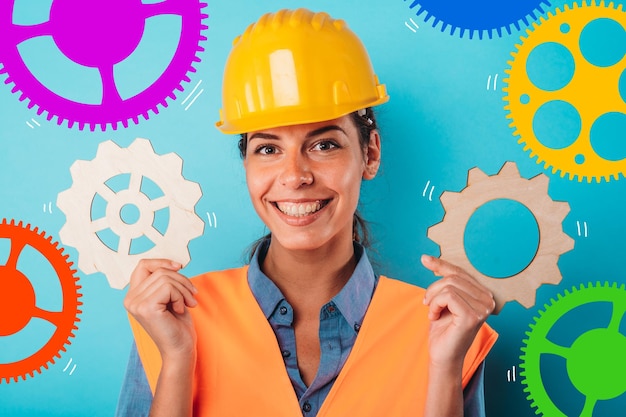 Foto mujer con casco une piezas de engranajes como concepto de asociación e integración