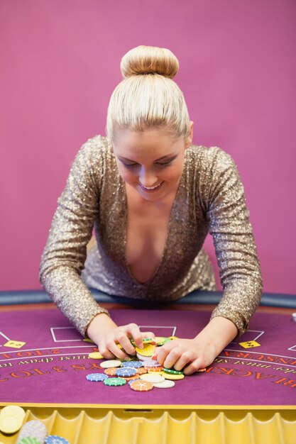 Foto mujer en un casino que agarra chips