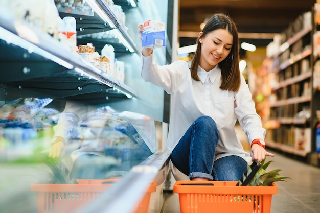 Foto mujer casual comprando comestibles y luciendo feliz