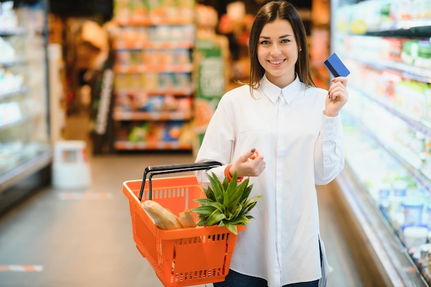 Mujer casual comprando comestibles y luciendo feliz