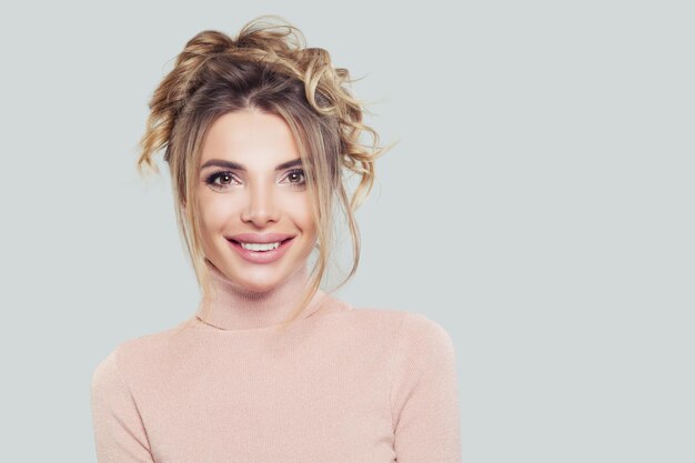 Mujer casual feliz en cuello alto rosa sobre fondo blanco Retrato sonriente de niña bonita modelo