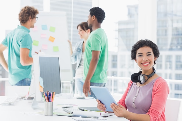 Mujer casual con grupo de colegas detrás en la oficina