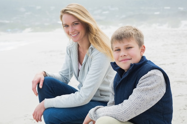 Mujer casual y su hijo se relaja en la playa