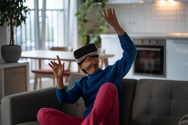 Mujer caucásica adulta usa gafas VR para entretenimiento y juegos con tecnología de realidad aumentada