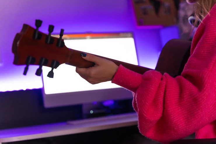 Foto mujer caucásica aprendiendo a tocar la guitarra con clases en línea en la computadora