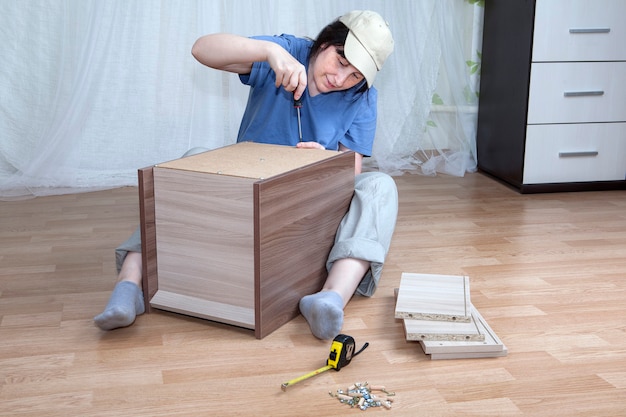 Foto una mujer caucásica autoensambla muebles nuevos.