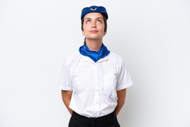 Mujer caucásica de azafata de avión aislada sobre fondo blanco y mirando hacia arriba