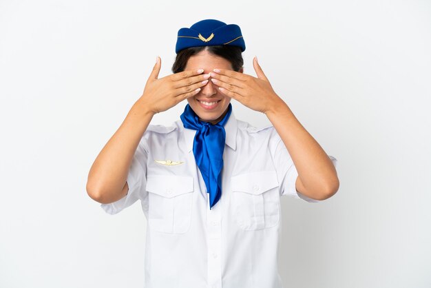 Mujer caucásica de azafata de avión aislada sobre fondo blanco que cubre los ojos con las manos