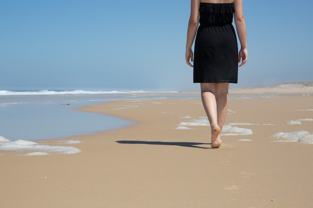 Mujer caucásica camina a lo largo de la costa hermosa