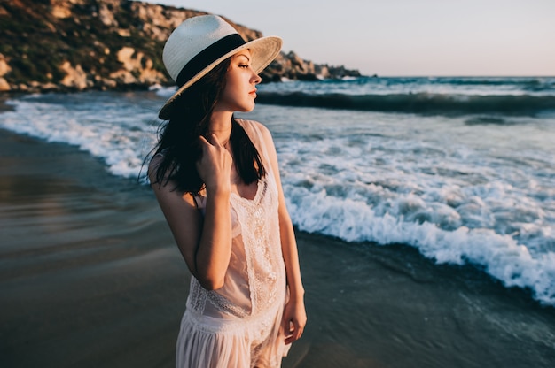 Mujer caucásica camina a lo largo de la costa hermosa